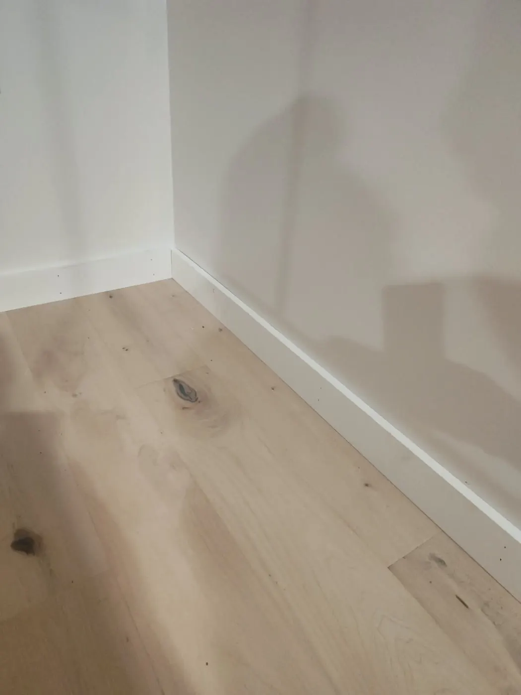 Close-up of the finished flooring and baseboard trim
