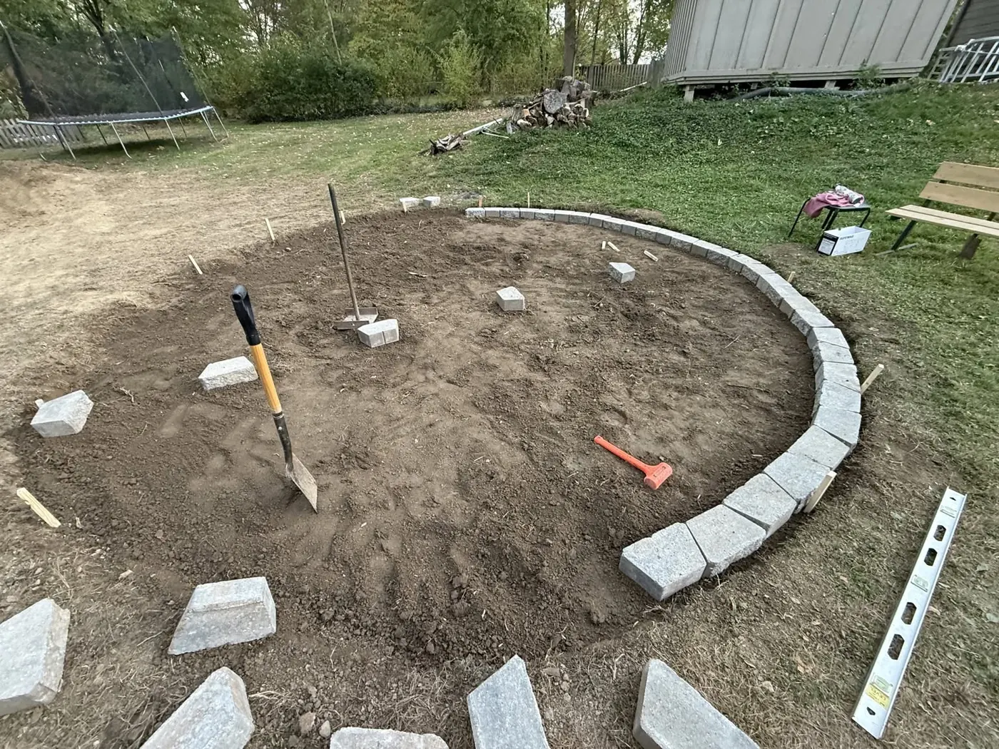 Stone border installation around the fire pit area