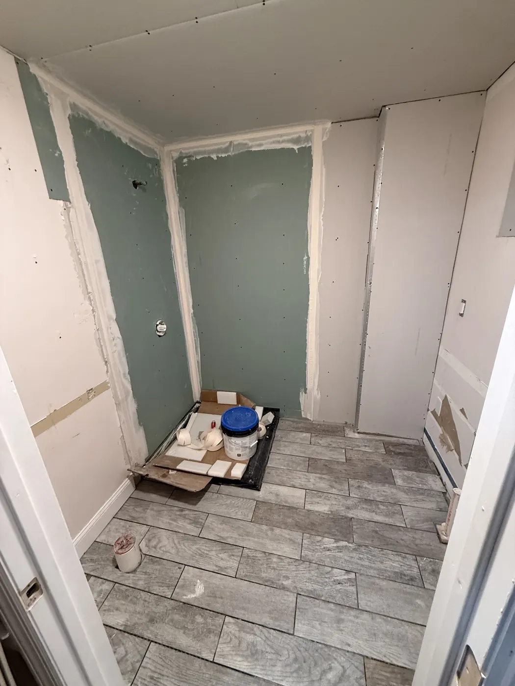 Bathroom flooring and drywall installation in progress