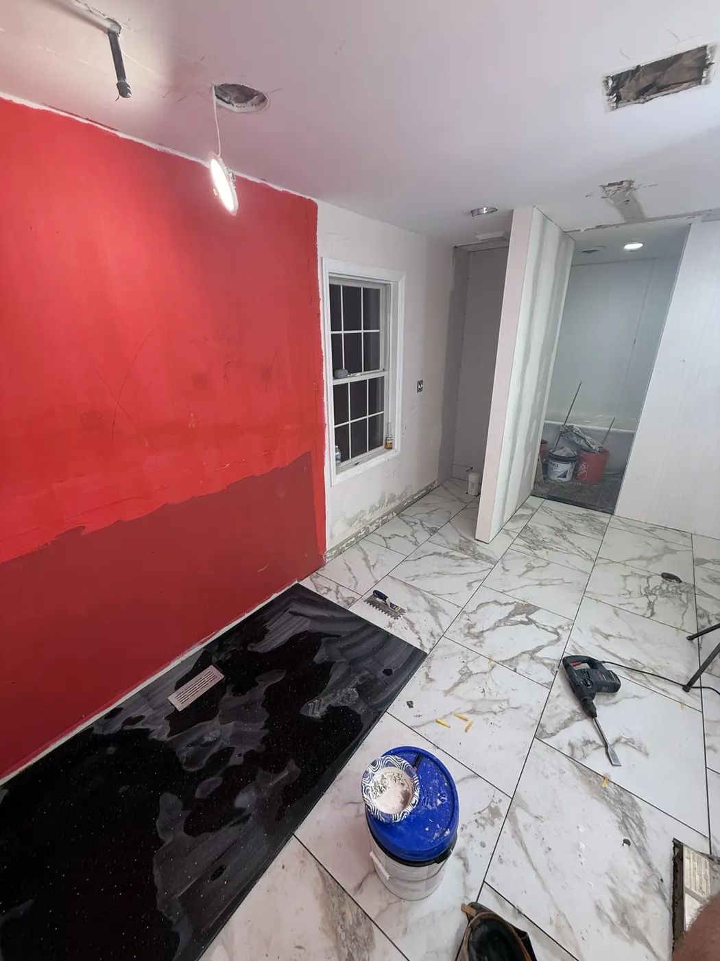 Bathroom tile installation progressing through the room