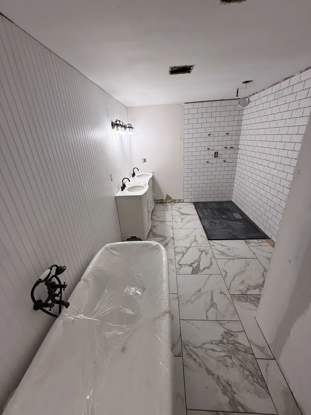 Tub, vanity, and shower fixtures being installed