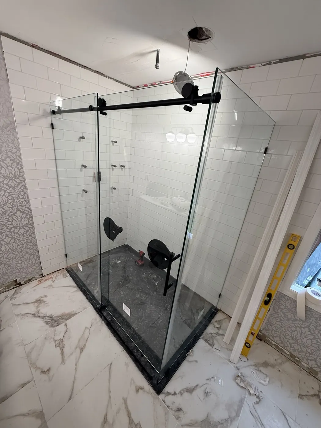 Glass shower enclosure being installed