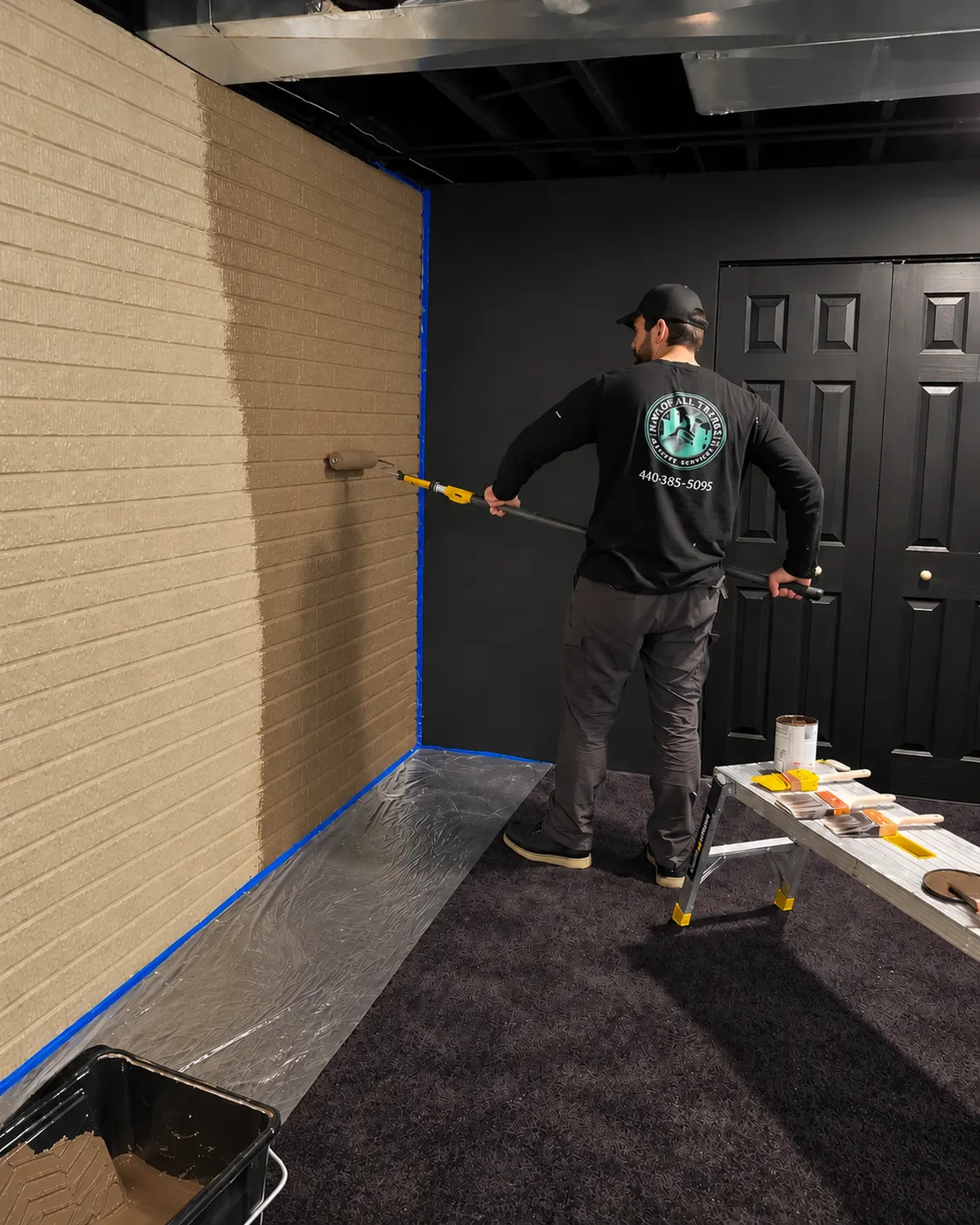 Nik painting an interior wall on site